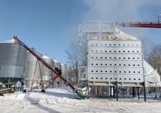 Steam rises from a grain dryer in operation on a farm.