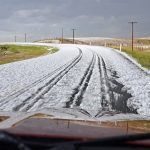 Hail covers a highway following a summer storm.