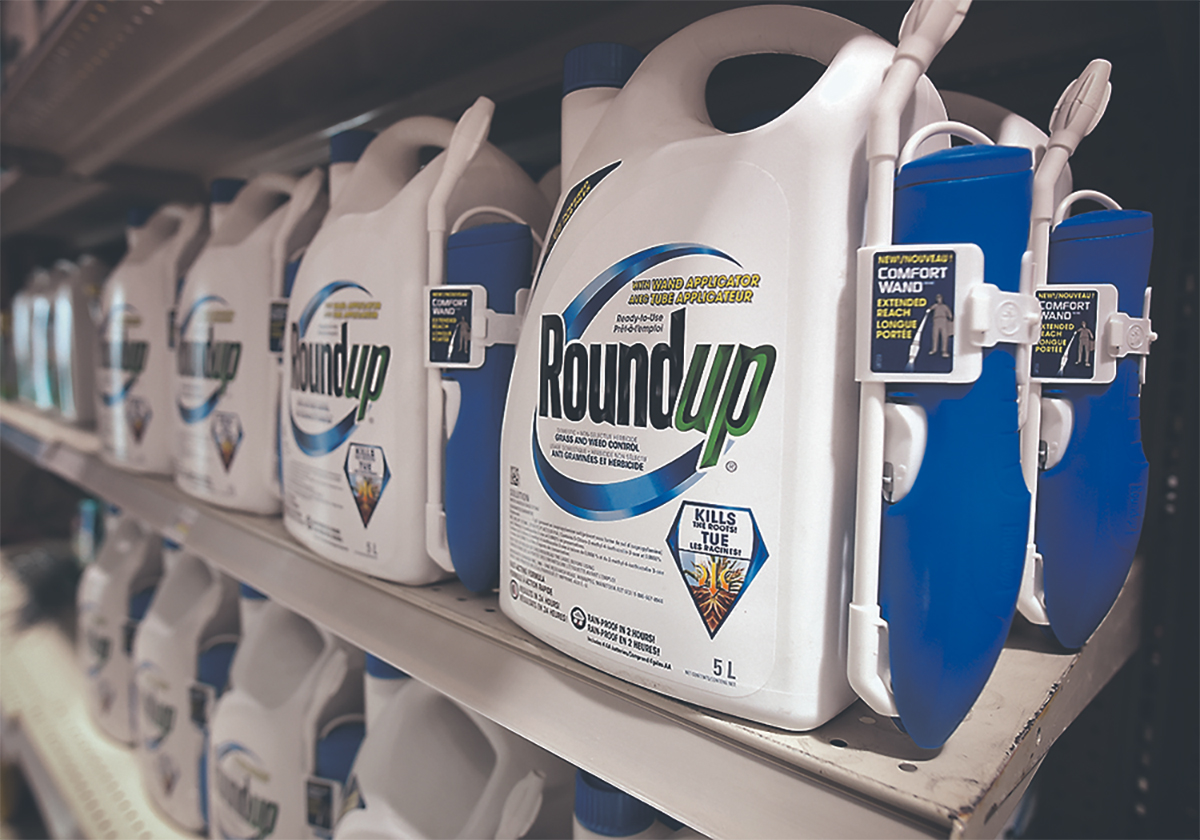 Containers of Roundup on display on a shelf in a store.