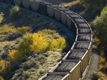A coal train rounds a bend photographed from above.