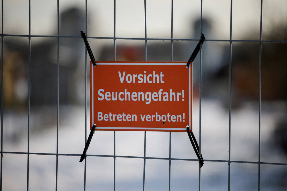 A sign with the inscription “Beware of epidemic danger! No trespassing!” hangs on a fence in front of a farm in Mehrow, Germany, Jan. 13, 2025.