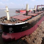 An overhead photo of a bulk container ship under construction in a dry dock in China.