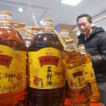 A customer buys cooking oil at a supermarket in China.
