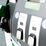Close-up of the options on a fuel pump with the nozzle secure in its holder in the background.