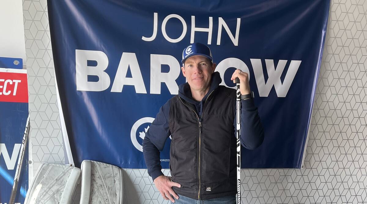 Conservative party agriculture critic John Barlow stands in front of a banner with his name on it.