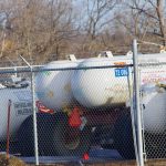Anhydrous ammonia tanks on wheels sit in a fenced lot in central Manitoba.
