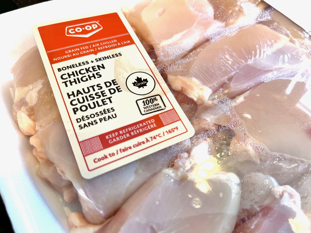 Chicken thighs on a white styrofoam tray, wrapped in plastic, at a Co-Op grocery store.