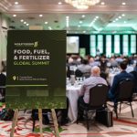 A sign at the back of a meeting room filled with people promoting the Food, Fuel and Fertilizer summit.