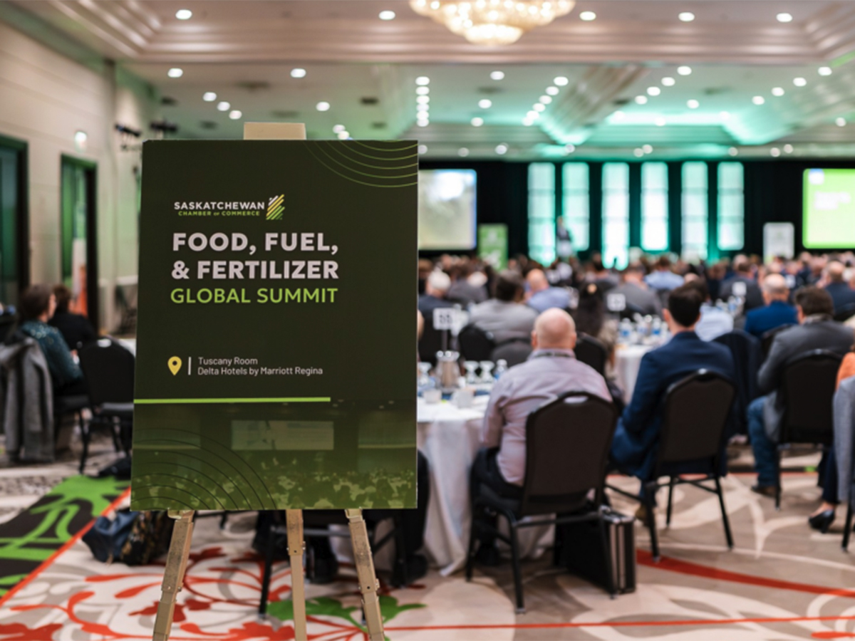 A sign at the back of a meeting room filled with people promoting the Food, Fuel and Fertilizer summit.