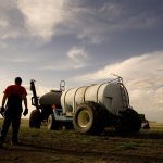 A farmer walks toward his air seeder.