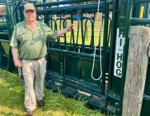 Myron Wigness stands with a Hi-Hog cattle squeeze unit.