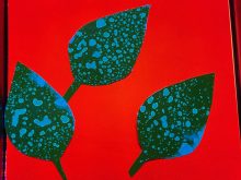 Pieces of paper shaped like leaves have drops all over them as they are used to illustrate how effectively spray from a sprayer is able to reach a plant's leaves.
