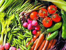 A colourful display of fresh vegetables including asparagus, beans, peas, potatoes, carrots, radishes, celery, cucumbers and tomatoes.
