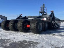 A picture of a Pro-Level 16XL scraper with special, wide, high-flotation tires described as "Batmobile" tires.