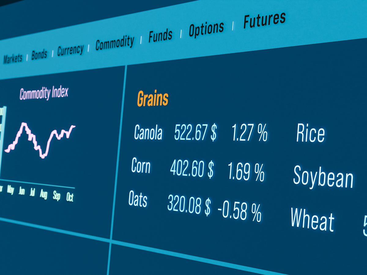 A stock photo of a commodities market information screen showing line graph and values for various commodities, like canola, corn and oats.