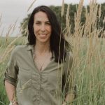 Kim Keller, Saskatchewan farmer, stands in a field of ripe wheat.