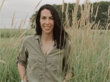 Kim Keller, Saskatchewan farmer, stands in a field of ripe wheat.