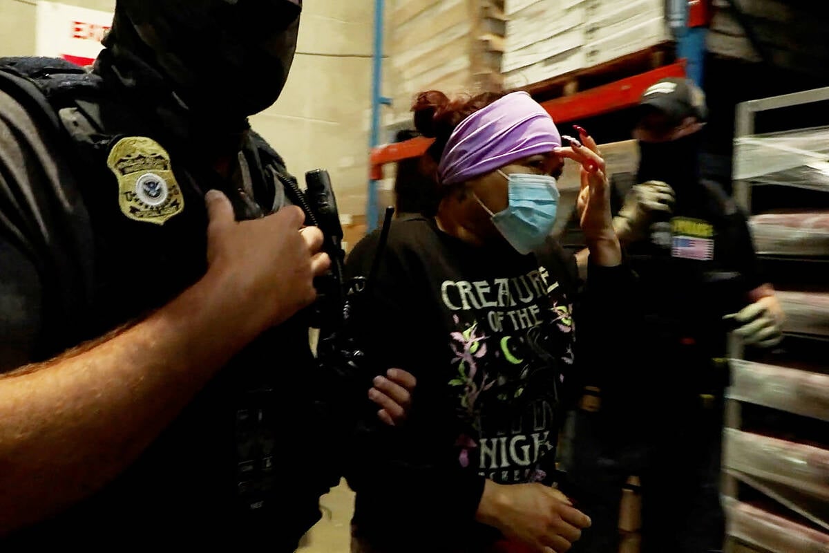 A woman is detained during a raid by U.S. Immigration and Customs Enforcement at a Glenn Valley Foods meat production plant in Omaha, Nebraska.