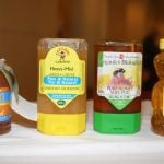 Four containers of honey - only one of which is actually a product of Canada - sit on a white tablecloth.