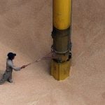 An Indonesian worker checks a big pipe used to suck tons of wheat flour at Tanjung Priok port in Jakarta.