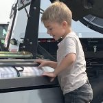 Three-year-old Liam Hrappstead gets a closer look at a Massey Ferguson round baler at Ag in Motion 2025.