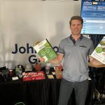 Joel Merkosky, president of Johnston's Grain, poses in the company booth at the Ag in Motion farm show near Langham, Saskatchewan.