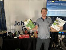 Joel Merkosky, president of Johnston's Grain, poses in the company booth at the Ag in Motion farm show near Langham, Saskatchewan.