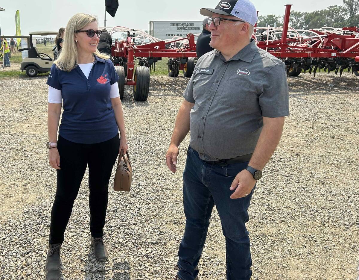 Canadian Chief Trade Commissioner Sara Wilshaw speaks with Scott Scherman of Bourgault industries at Ag In Motion 2025, near Langham, Sask.