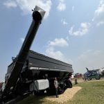 Shawn Berry, territory manager for Unverferth Manufacturing Company is dwarfed by the sheer size of the new Brent 3298 Avalanche dual-auger grain cart with its 3,150 bushel hopper capacity.