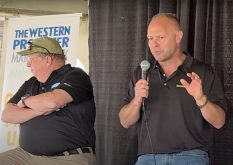 Jerry Klassen, right, and Bruce Burnett talk markets at the Ag in Motion farm show near Langham, Sask.