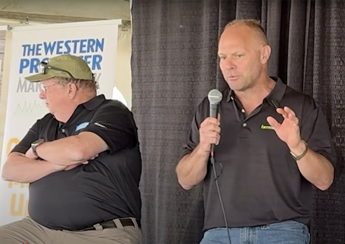 Jerry Klassen, right, and Bruce Burnett talk markets at the Ag in Motion farm show near Langham, Sask.