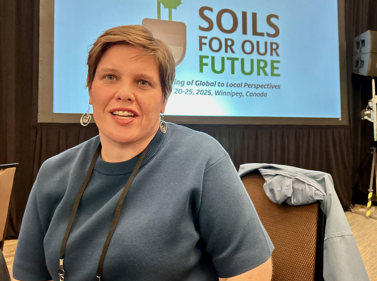 Sabrina Peric, a University of Calgary professor, is photographed in front of a "Soils for Our Future" banner.