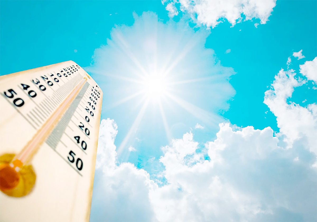 Stock photo looking upward toward the sun with an old thermometer with red fluid in it along the lefthand side of the image.