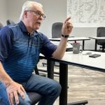 Former federal agriculture minister Gerry Ritz sits at a table, gesturing with his left hand as he speaks, in the RM of Mervin's office, where he has served as Reeve since 2020.