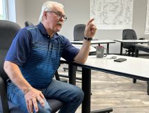 Former federal agriculture minister Gerry Ritz sits at a table, gesturing with his left hand as he speaks, in the RM of Mervin's office, where he has served as Reeve since 2020.