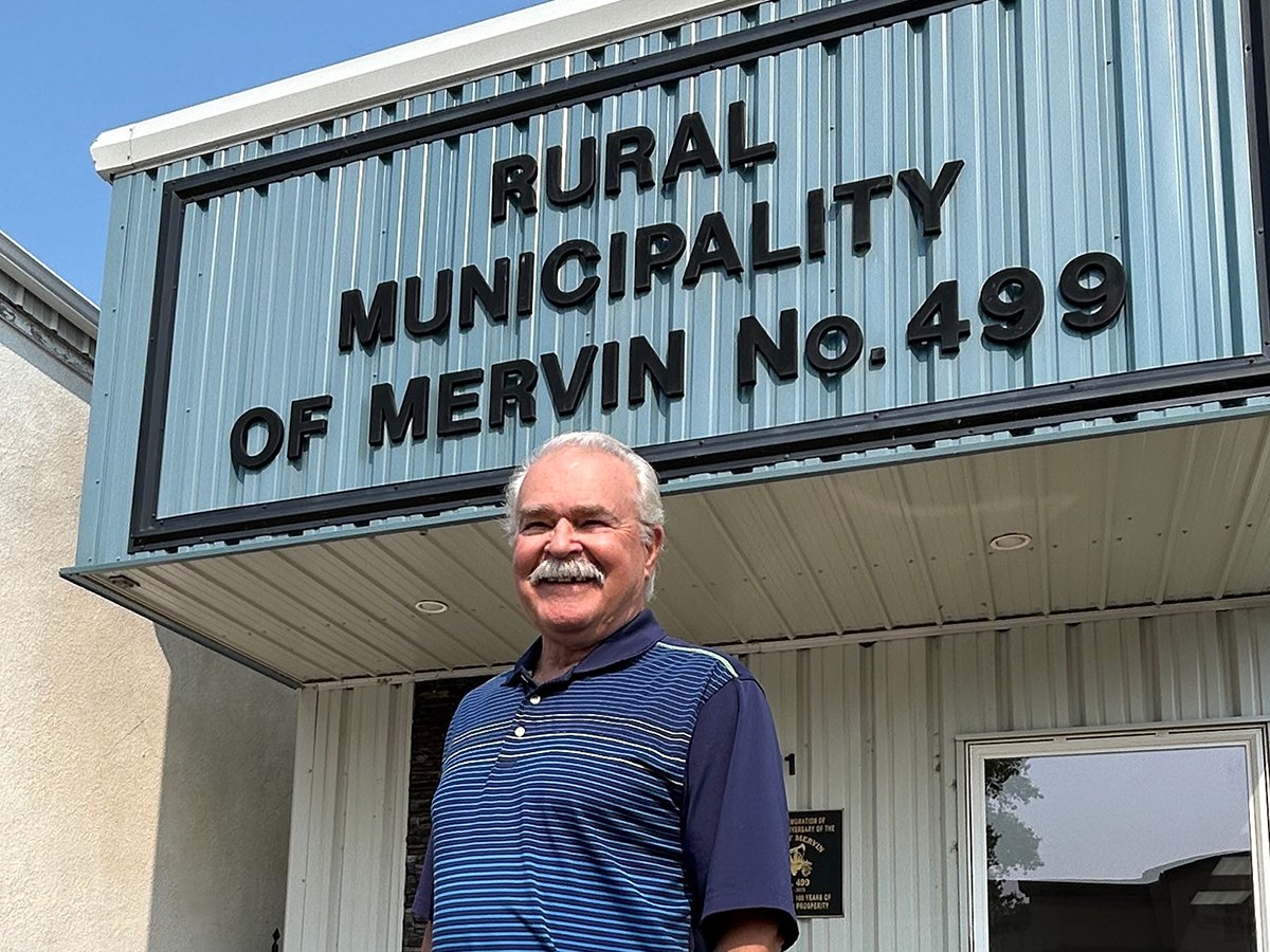 Former federal agriculture minister Gerry Ritz is photographed standing in front of a building with "Rural Municipality of Mervin No. 499" written on it. Ritz has been Reeve of this RM since 2020.
