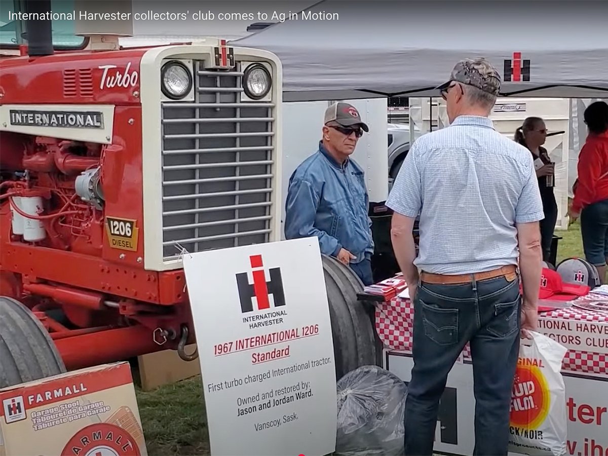 Two men in ball caps chat in front of a vintage International 1206 tractor on display at the Western Canada International Harvester Club, chapter 38, booth at the Ag in Motion farm show near Langham, Sask., in July of 2025.