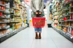 Supermarket aisle, woman legs and basket for shopping in grocery store. Customer, organic grocery shopping and healthy food on groceries sale shelf or eco friendly retail purchase in health shop
