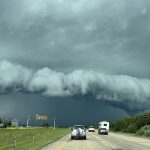 Dark storm clouds photographed from inside a vehicle on Highway 2 near Lacombe, Alberta, on August 10, 2025.