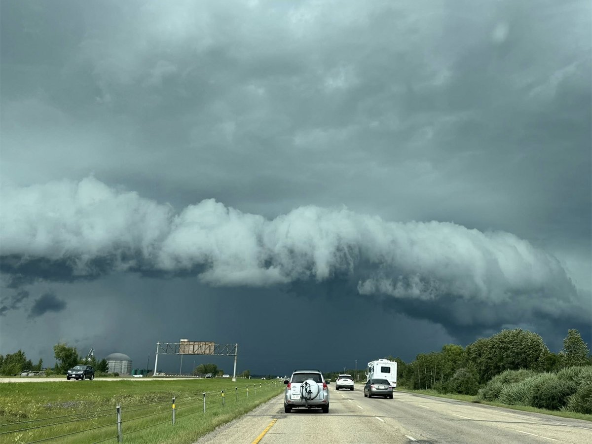 Dark storm clouds photographed from inside a vehicle on Highway 2 near Lacombe, Alberta, on August 10, 2025.