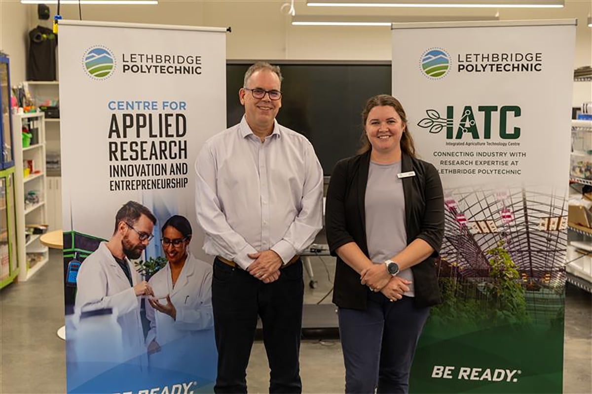 Dr. Andrew Dunlop, associate vice-president – research, left, and Alexis Buzzee, IATC business manager, CARIE, stand together in front of promotional banners during a funding announcement at Lethbridge Polytech on August 13, 2025.
