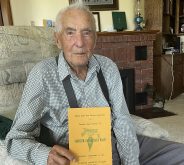 103-year-old Burns Wood, seated in an easy chair and wearing a collared short and suspenders, holds the Alberta Sugar Beet Growers' 50th anniversary celebration booklet from 1975.