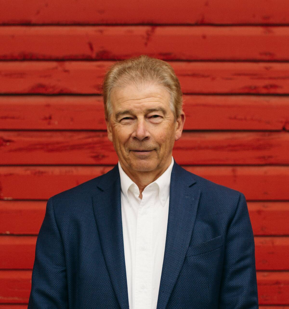 Dennis Laycraft, Executive Vice President of the Canadian Cattle Association is pictured standing against a vivid red barn in the background.