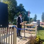 A man in a black cowboy hat speaks from a lectern at Canada's Outdoor Farm Show in Ontario.