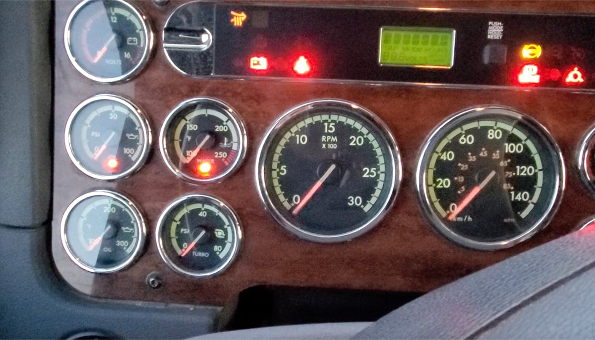 Close-up of the dash of a diesel truck showing a number of warning lights on.