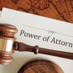 A stock image of a "Power of Attorney" document with a judge's gavel on top of it.