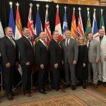 Provincial agriculture ministers and federal ag minister Heath MacDonald pose for a photo in front of the flags of each province and Canada during a meeting in Winnipeg in September, 2025.