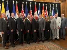 Provincial agriculture ministers and federal ag minister Heath MacDonald pose for a photo in front of the flags of each province and Canada during a meeting in Winnipeg in September, 2025.