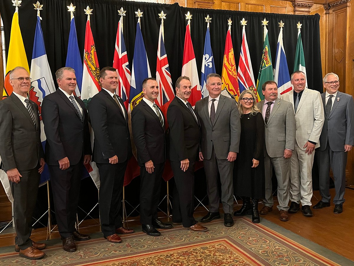 Provincial agriculture ministers and federal ag minister Heath MacDonald pose for a photo in front of the flags of each province and Canada during a meeting in Winnipeg in September, 2025.