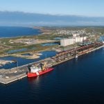 An aerial view of a red and white Canadian Coast Guard vessel dockside at the Port of Churchill.